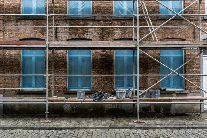 Stelling tegen een bakstenen rijhuisgevel tijdens een reinigingsbeurt